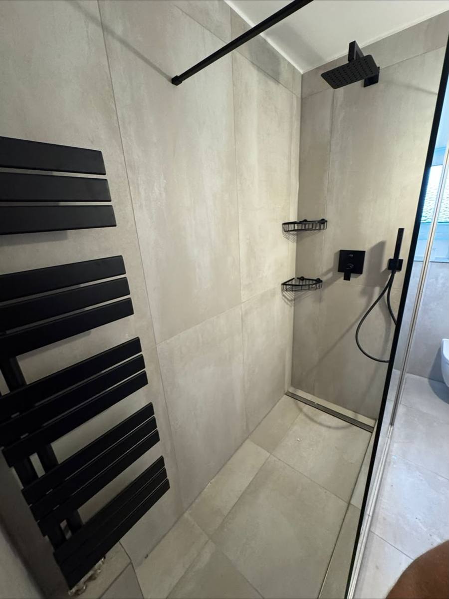 Modernes Duschbad mit schwarzer Regenbrause