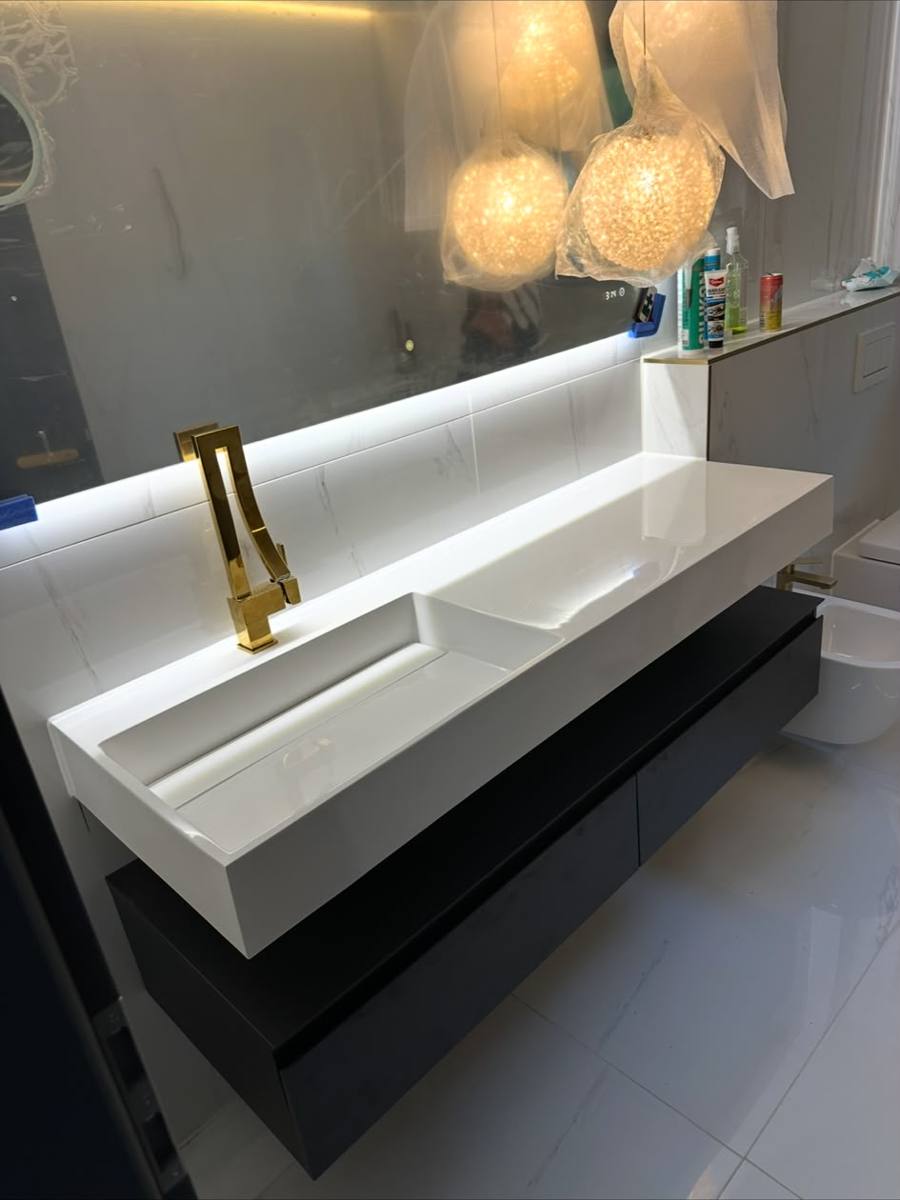 Designer-Bad mit goldener Armatur und beleuchtetem Spiegel