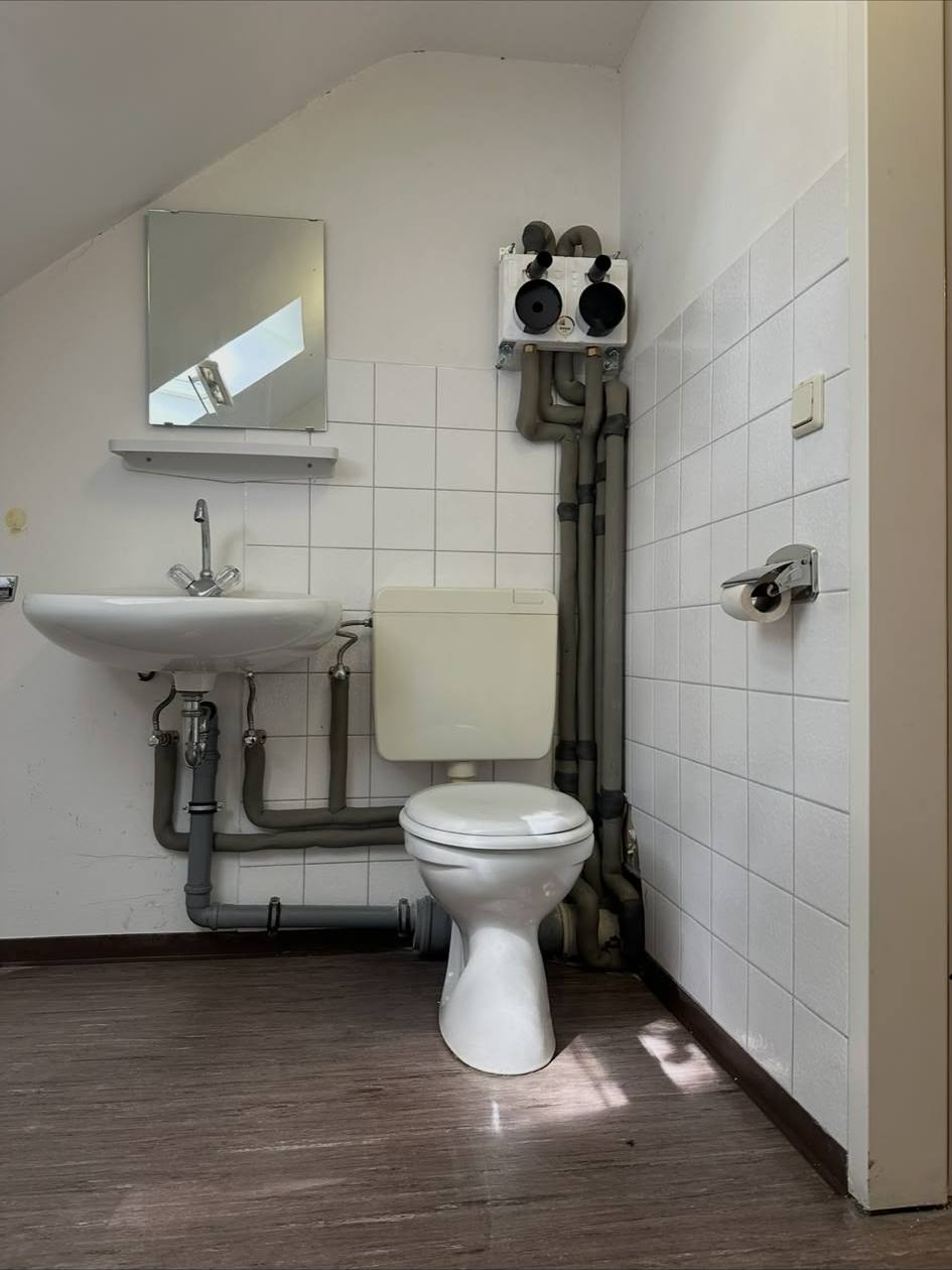 Altes WC mit Aufputz-Rohren vor der Sanierung